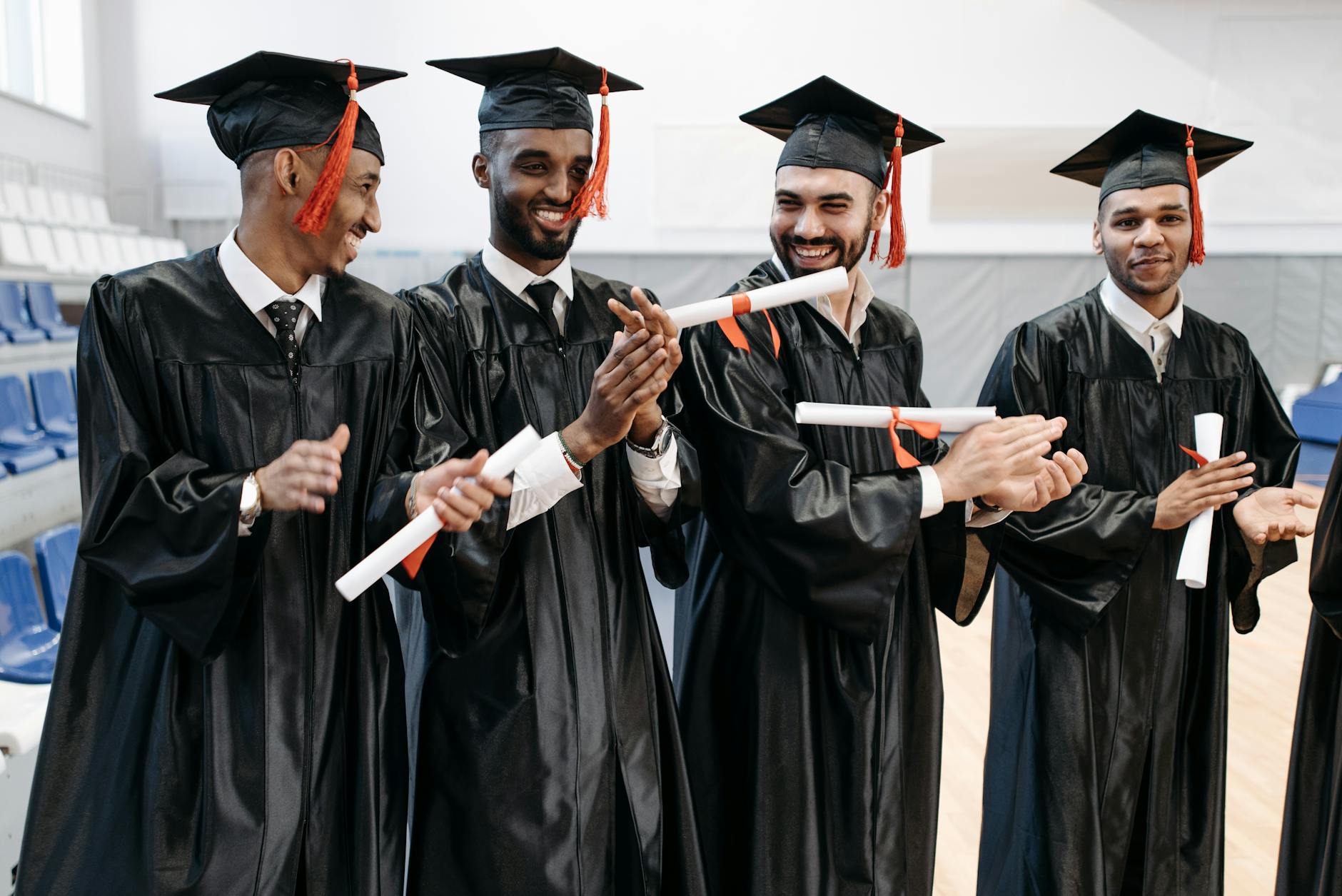 Joyeux diplômés en casquettes et robes célébrant leur réussite à l'intérieur.